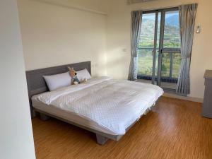 a bedroom with a bed with a teddy bear on it at 枋山六號 in Shizi