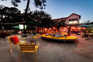 a large yellow surfboard sitting next to chairs and tables at JO&JOE Hossegor in Hossegor