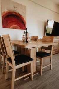 una mesa de madera y sillas con copas de vino. en Sivota Luxury Apartments en Sivota