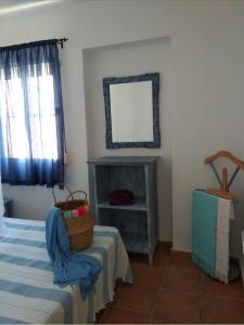 a room with a bed and a mirror and a table at El Rincón de Bolonia in Bolonia