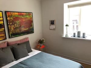 a bedroom with a blue bed and a window at Stemningsfuld lejlighed - 3 minutters gang fra H.C. Andersens Hus in Odense