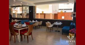 a dining room with tables and chairs in a restaurant at Jewel Al Nasr Hotel & Apartments in Cairo