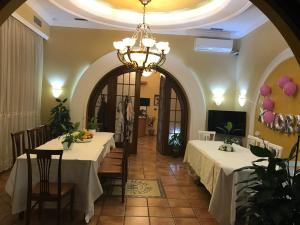 uma sala de jantar com duas mesas e um lustre em Hotel Nais em Durrës