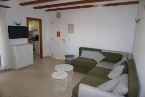 uma sala de estar com um sofá verde e duas mesas em Sol y Mar em Oliva