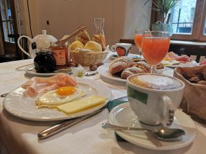 uma mesa com pratos de comida para o pequeno-almoço e uma chávena de café em Alla Torre del Barbarossa B&B FORESTERIA em Mandello del Lario