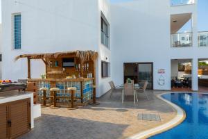a villa with a swimming pool and a house at Seafront Protaras Villas in Protaras
