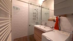 a white bathroom with a sink and a shower at Kamocsay Vendégház in Mór