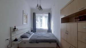 a white bedroom with a bed and a window at Kamocsay Vendégház in Mór