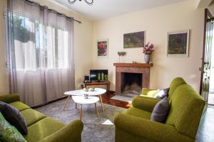sala de estar con sillas verdes y chimenea en Villa Cosy Nook, en Funchal