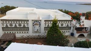 a white house with a christmas tree in front of it at Galazio Kyma in Agios Ioannis