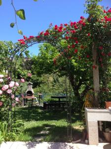 an arch with roses on it in a garden at Apartments and Rooms Knez in Portorož