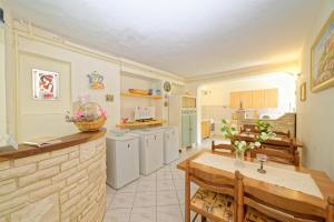 a kitchen and dining room with a table and chairs at Guest House Jolanda in Medulin