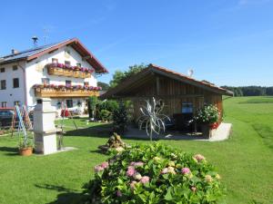 une maison avec beaucoup de fleurs devant elle dans l'établissement Feichtlhof, à Taching am See