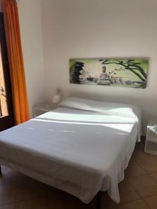 een wit bed in een slaapkamer met een foto aan de muur bij Tiffany 2 in Palau