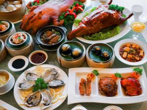 a table topped with plates of food with different foods at Swissotel Bangkok Ratchada in Bangkok