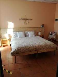 a bedroom with a large bed with a wooden headboard at Agriturismo Boschi in Reggiolo