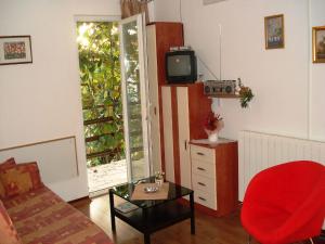 a living room with a red chair and a tv at Apartments Percan 448 in Krnica