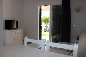 a room with a table and two chairs and a television at Apartamentos Saura in Cala en Blanes
