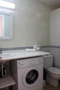 a bathroom with a washing machine and a sink at Apartamentos Saura in Cala en Blanes