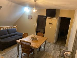 un salon avec une table et un canapé bleu dans l'établissement CHEZ MARIA ET JOSE, à Coucy-le-Château-Auffrique