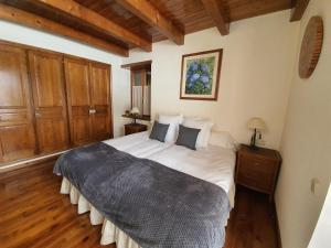 una camera con un grande letto e pavimenti in legno di VILAC 2 a Vilac