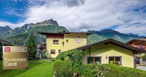 a building with a sign in front of a mountain at Appartements Kuprian in Längenfeld