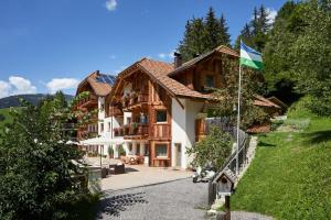 a house with a flag in front of it at Residence Baron in San Vigilio Di Marebbe