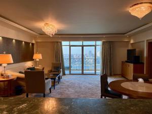 Chez Haytham At Four Seasons Nile Plaza Residential Suite في القاهرة: غرفة في الفندق مع غرفة معيشة كبيرة