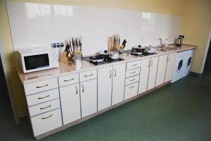 a kitchen with white cabinets and a microwave at City Hostel Panorama in Uzhhorod