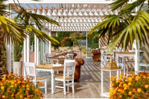 a restaurant with tables and chairs and a pergola at Boffenigo Panorama & Experience Hotel in Costermano