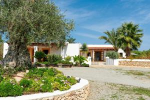 una casa con un árbol delante de ella en Villa Sa Cuina, en Sant Rafel de sa Creu