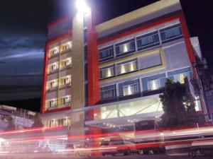 un grand bâtiment avec un éclairage de rue devant lui dans l'établissement Hotel MJ, à Samarinda