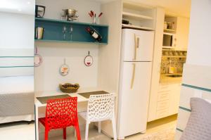 a kitchen with a table and two chairs and a refrigerator at Apartamento - Itaipava in Itaipava