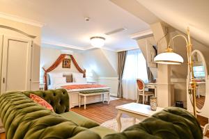 a living room with a couch and a bed at Grant Boutique Hotel in Arad