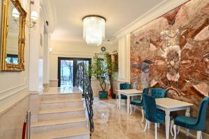 un vestíbulo con mesas y sillas y una pared de piedra en Grant Boutique Hotel, en Arad