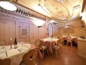 un ristorante con tavoli, sedie e bottiglie di vino di Rifugio Capanna Passo Valles a Falcade