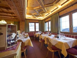 a row of tables in a restaurant with windows at Rifugio Capanna Passo Valles in Falcade