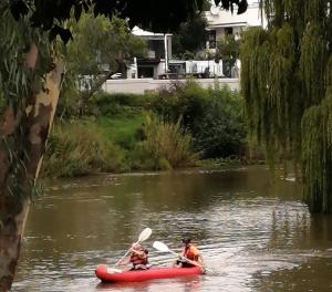 a group of people in a red canoe on a river at The Place Guesthouse Parys in Parys