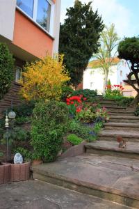 a garden with flowers and stairs in front of a building at Haus Müller Adelheid in Hilders