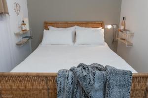 Un dormitorio con una cama con una manta. en Ay La en El-Rom