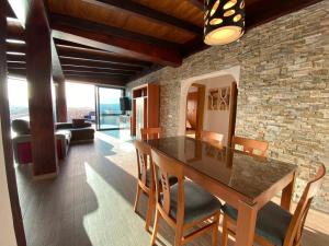a kitchen with a table and chairs and a stone wall at VILLA LOBA WITH PRIVATE POOL in Costa Calma