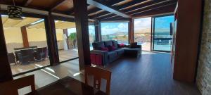 un soggiorno con divano, sedie e finestre di VILLA LOBA WITH PRIVATE POOL a Costa Calma