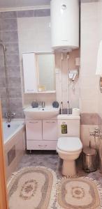 a bathroom with a toilet and a sink and a tub at Аблайхана 1/3 in Kokshetau