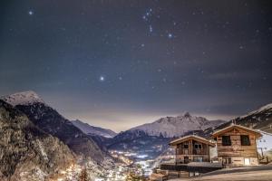 a starry night in the mountains with two houses at Haus Melisande in Sölden