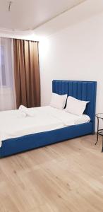 two beds in a room with a blue headboard at Аблайхана 1/3 in Kokshetau