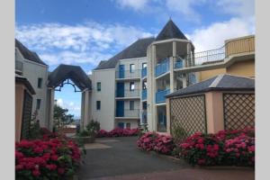 Grand appartement 4 étoiles vue mer et 2 terrasses في تالمونت: عمارة سكنية كبيرة وامامها زهور