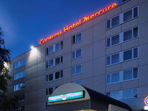 ein Hotel mit einem Neonschild auf der Seite in der Unterkunft Congress Hotel Mercure Nürnberg an der Messe in Nürnberg