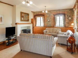 a living room with two couches and a tv at The Coach House in Piltown