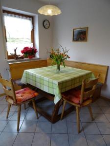 a dining room table with a vase of flowers on it at Ferienwohnung Wehner in Seiferts