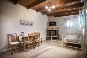 a living room with a table and chairs and a tv at Elleana south Corfu in Agios Georgios